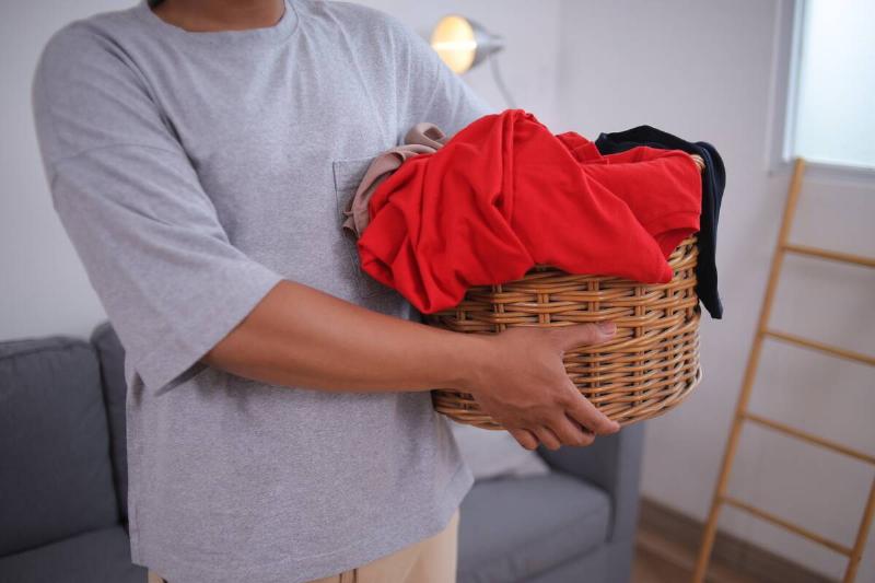 Laundry basket with red shirt on top. 