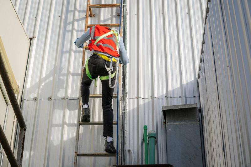 Worker climbing down ladder.