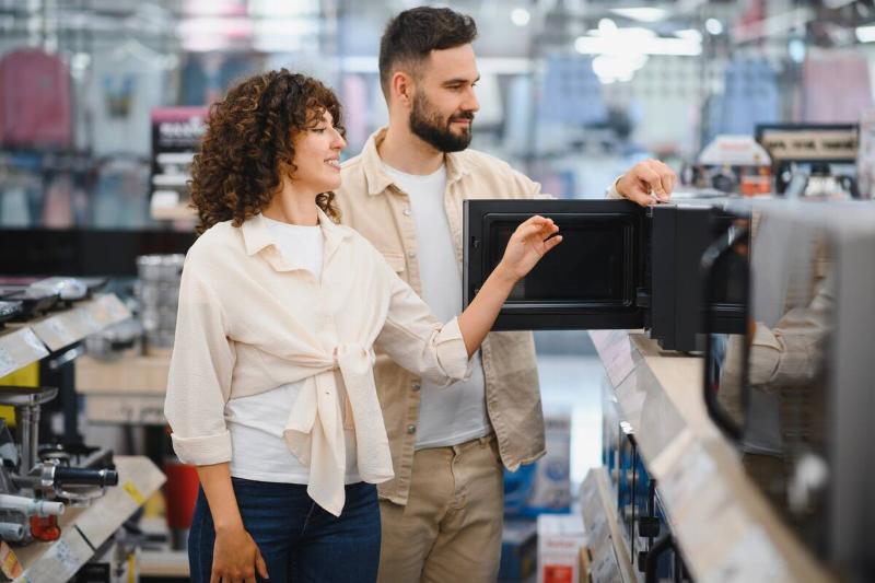 Man and woman shopping for a microwave. 