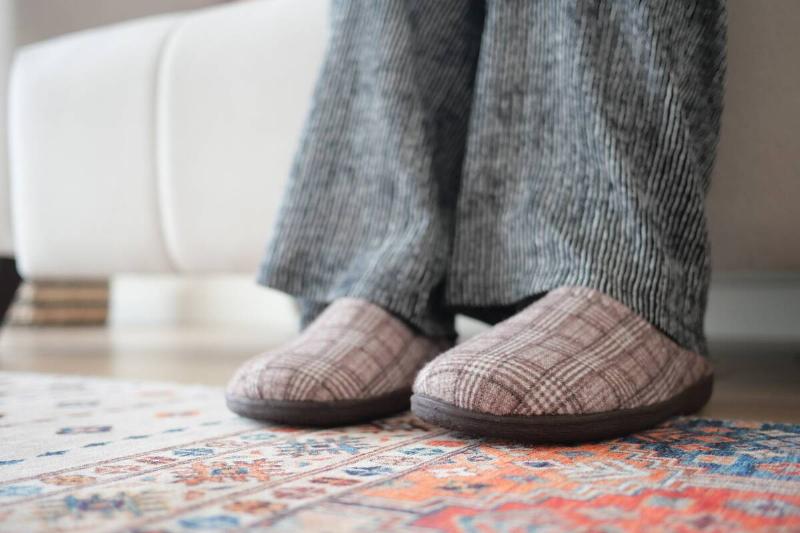 Feet in slippers on rug. 