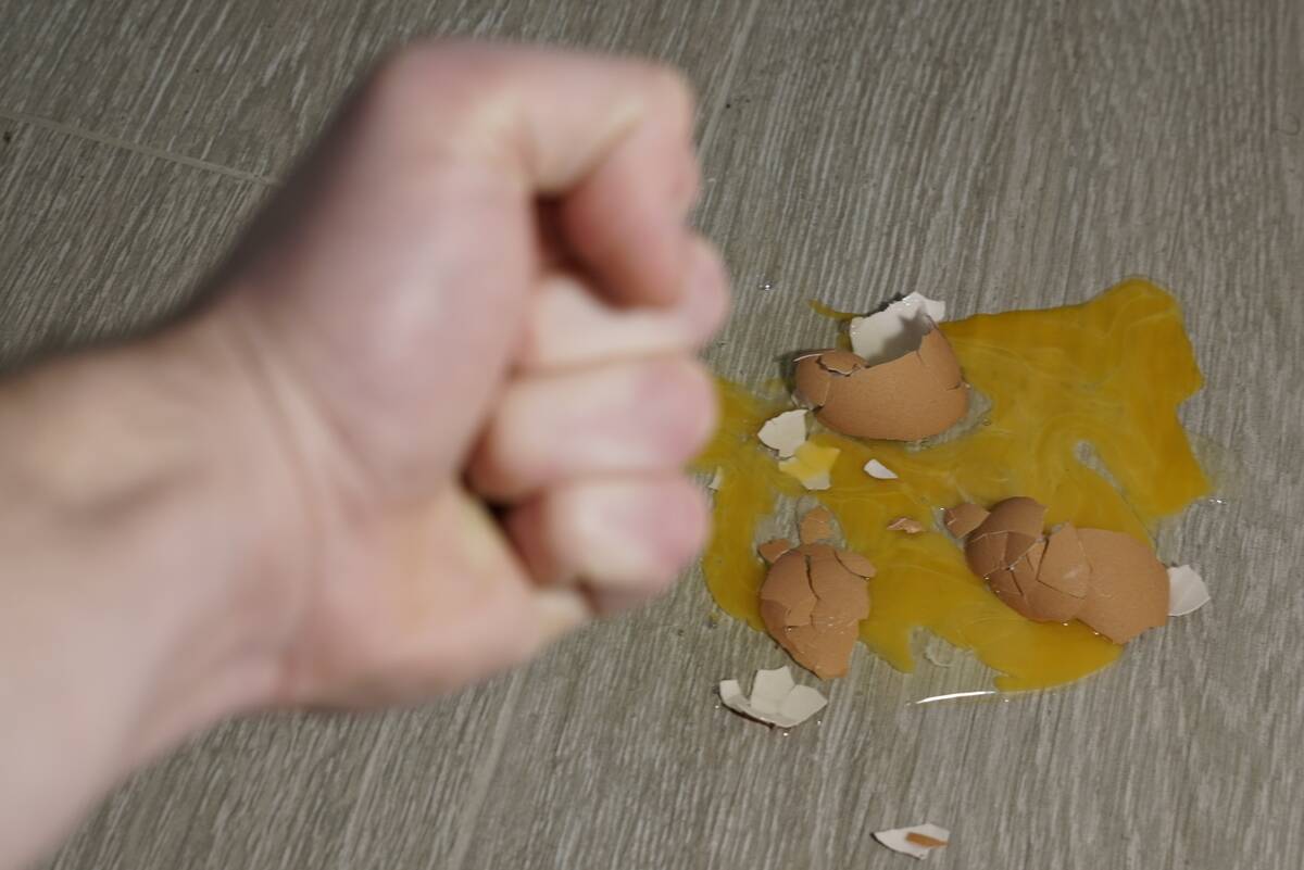 Broken raw egg on the floor.