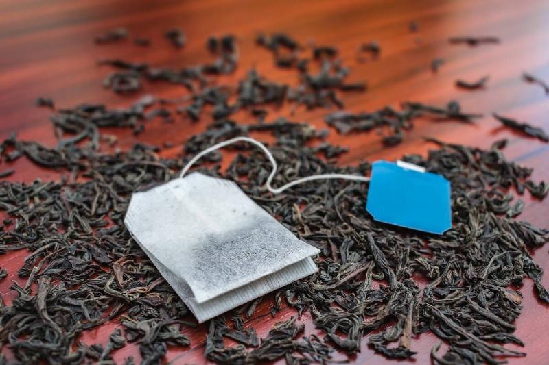 A tea bag on loose black tea.