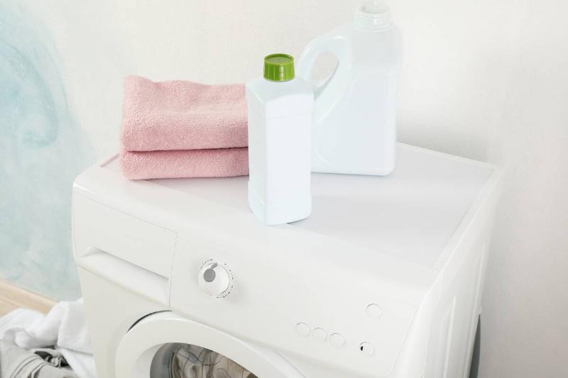 A bottle of stain remover on top of a dryer. 