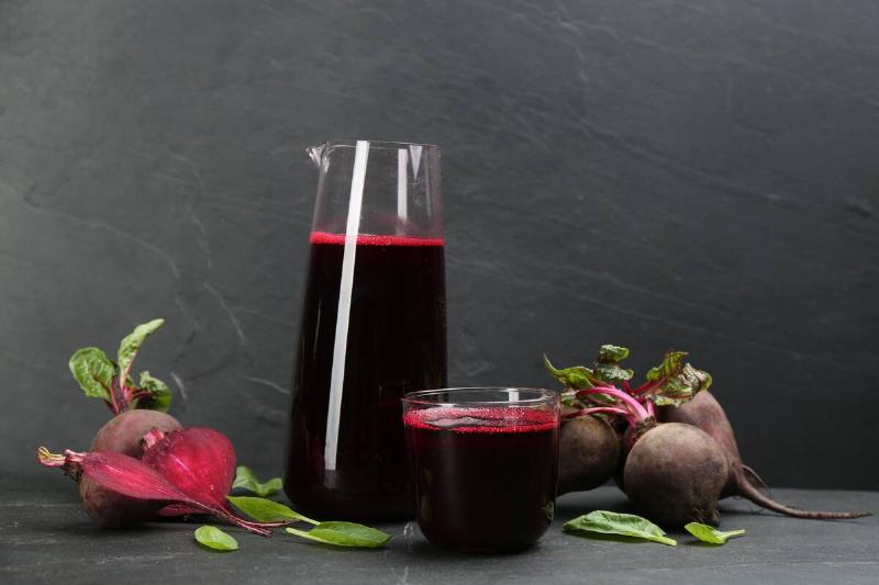 Freshly made beet juice on black table with beets. 