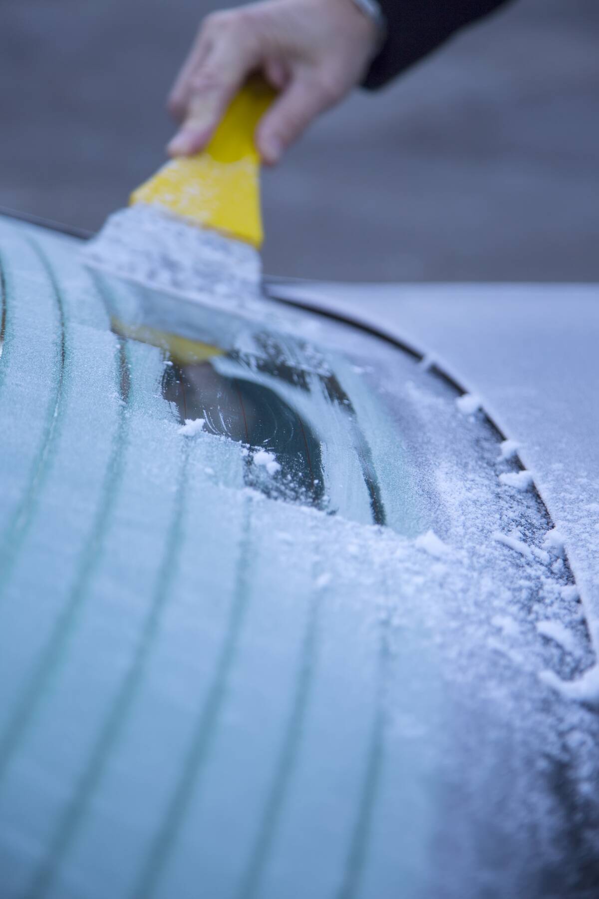 Scraping ice off of a car window. 