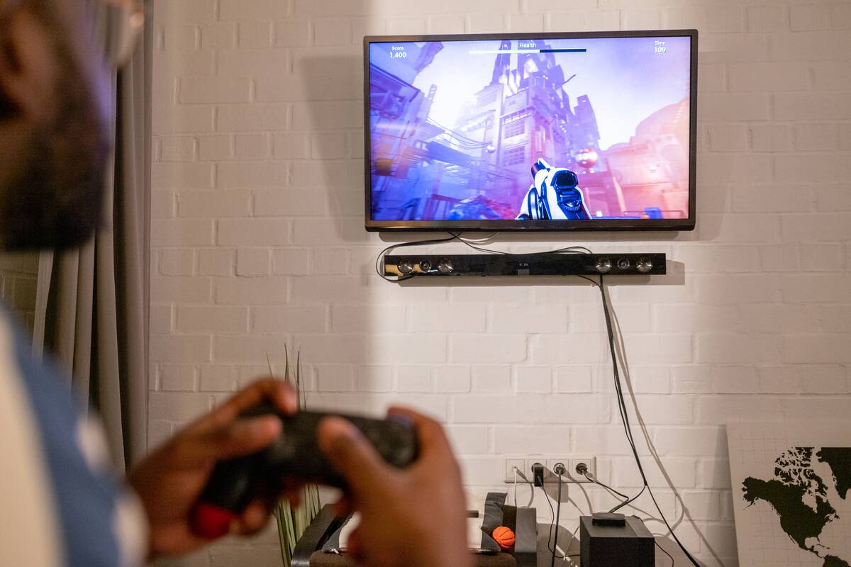 Man playing video games on gaming console connected to a TV. 
