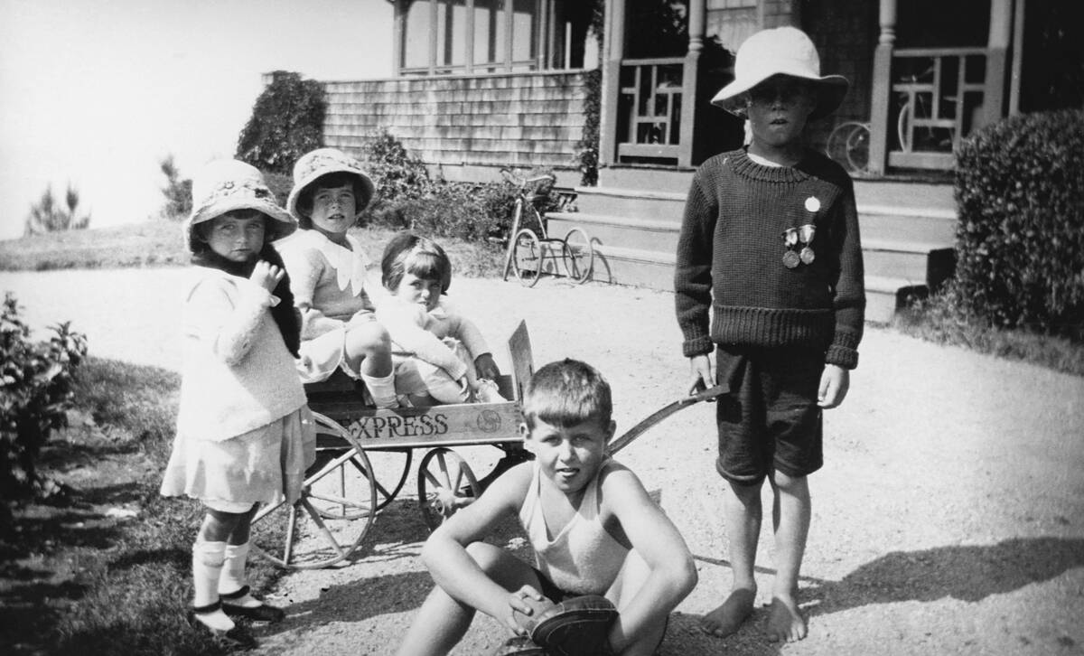 John F. Kennedy (pulling wagon), and siblings Joe Jr., Kathleen, Rosemary, and Eunice.