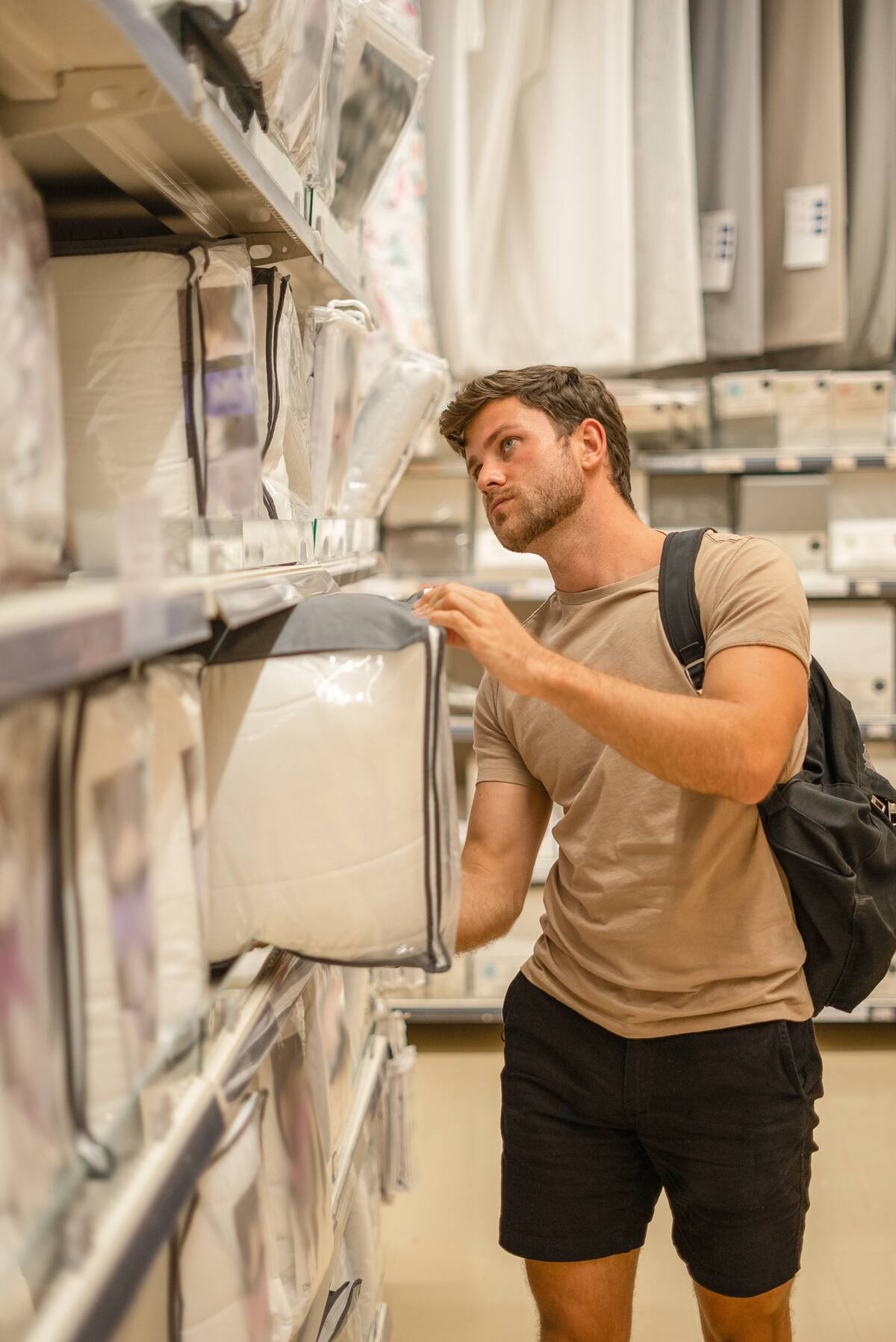 Man shopping for sheets set. 