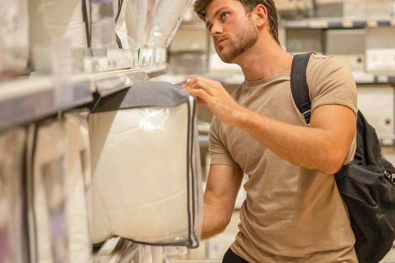 мужчина-покупатель выбирает одеяло-в-магазине-2026-01-08-05-27-21-utc Мужчина покупает набор простыней.