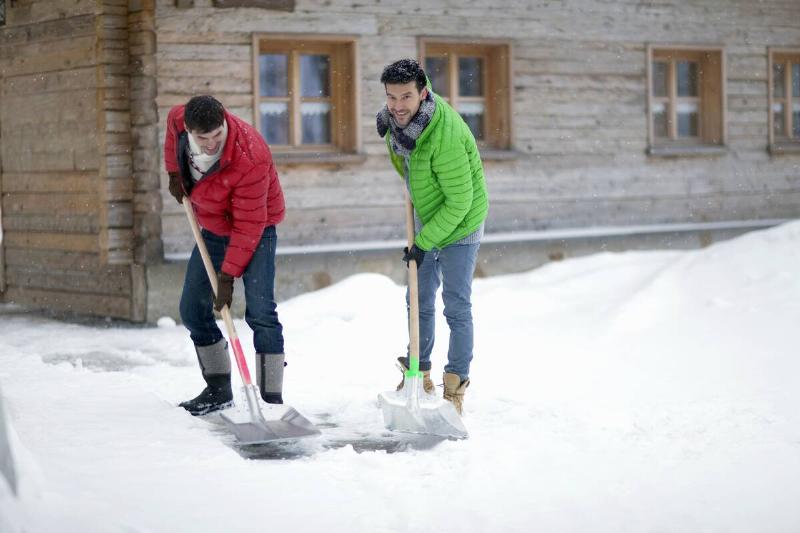 Two man shoveling snow together. 