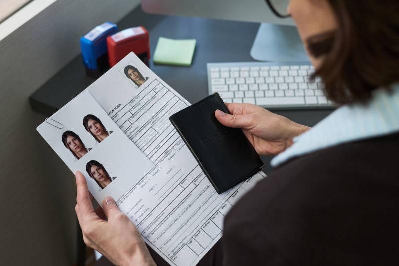 A woman holding a passport and visa application documents. 