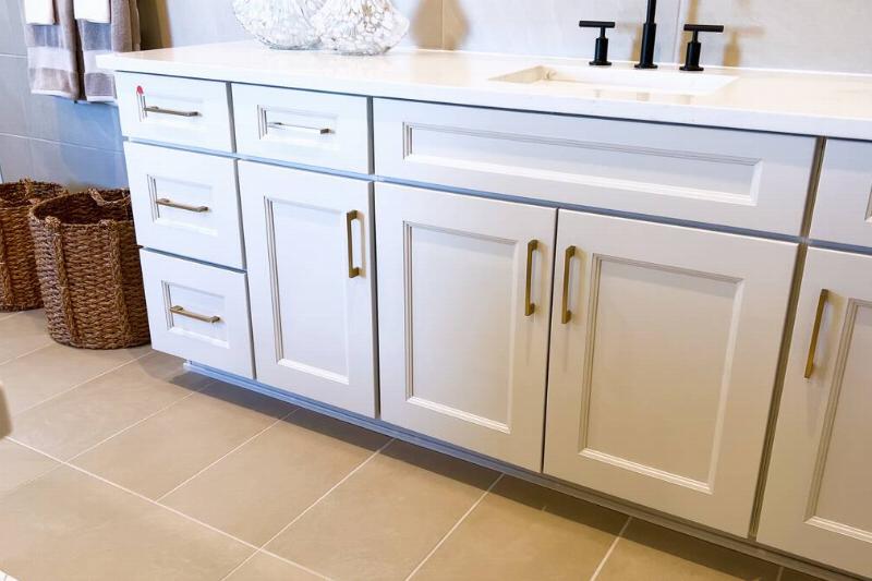 White bathroom cabinets with gold hardware. 