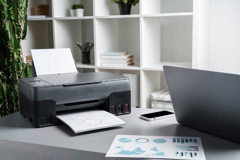 Modern printer on desk in office. 