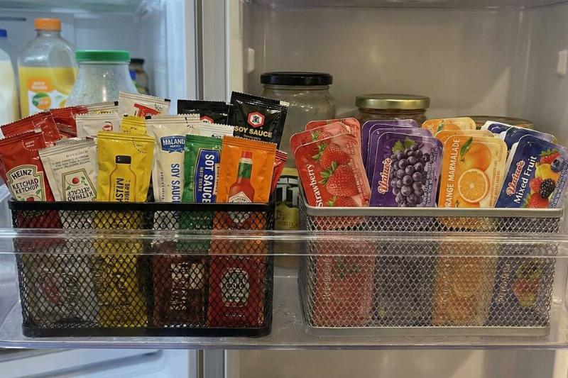 Two pencil holders holding packets in the fridge door. 