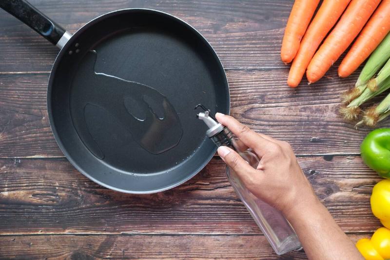 Pouring vegetable oil into frying pan.