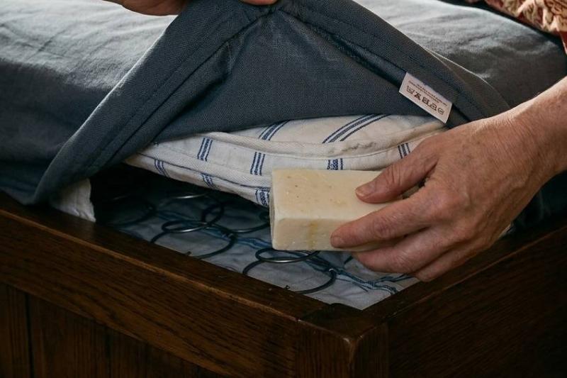 мыльный лист Руки кладут кусок мыла под простыню.