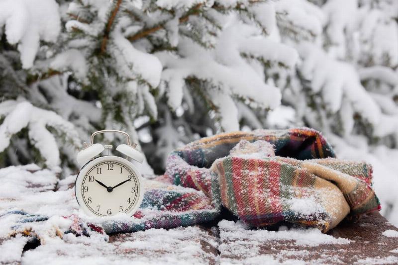 Blanket in the snow with a clock. 