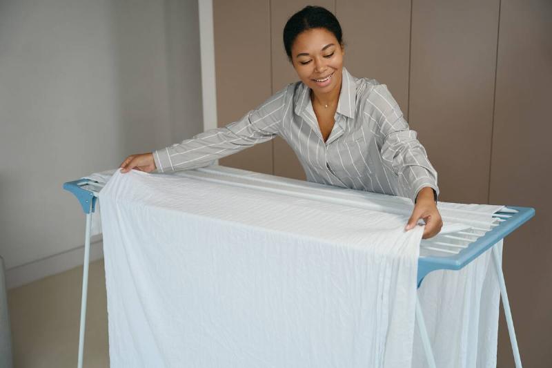 Woman hanging sheets up to dry. 