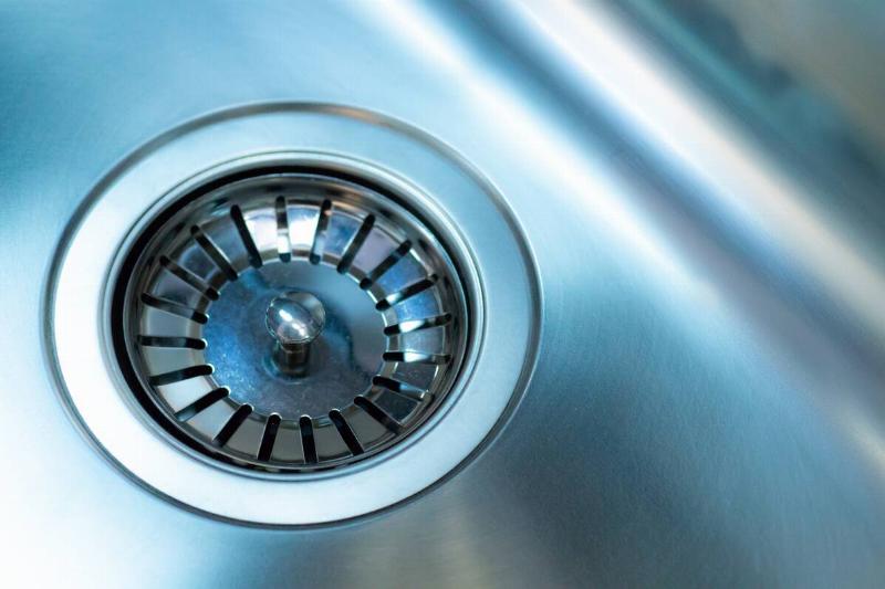 Close-up of a drain plug in the drain of a metal sink