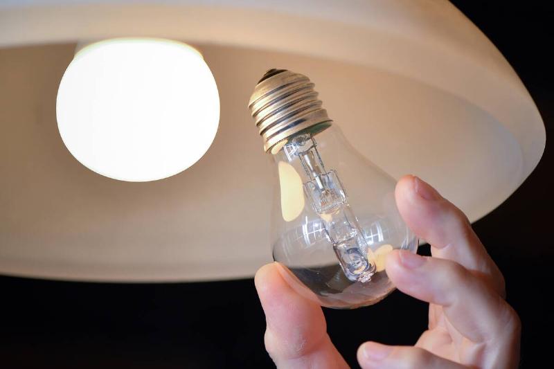 Hand replacing a lightbulb in a lamp. 