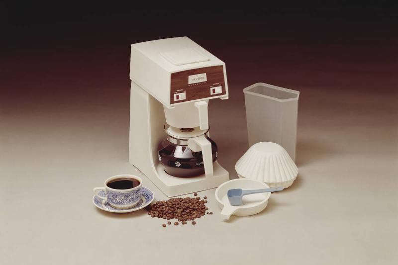 Vintage coffee maker with coffee cup and beans.