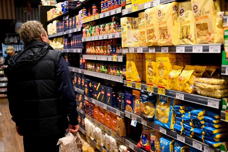 Man browsing the pasta aisle of a grocery store