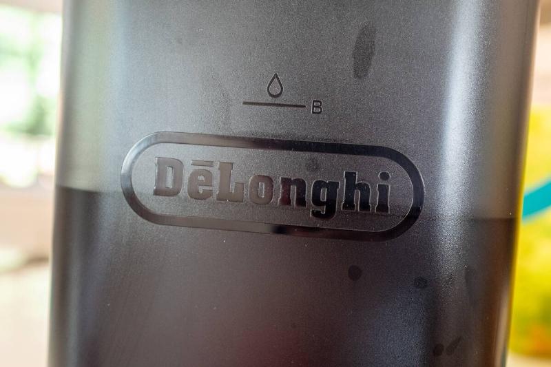 Close-up of DeLonghi logo on coffee maker. 
