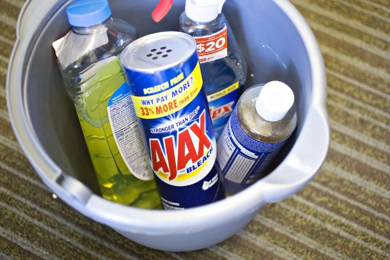 Ajax brand cleaner and other cleaners in a bin. 