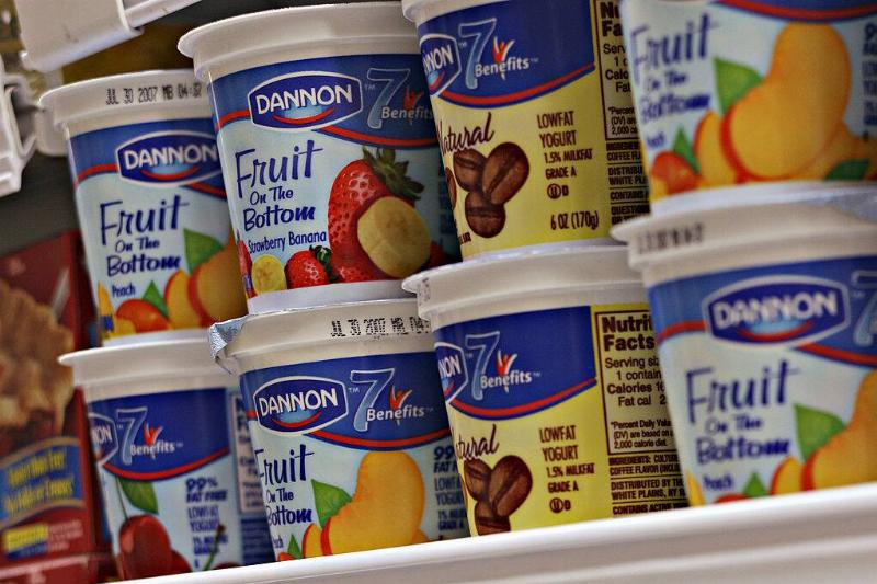 Containers of Dannon yogurt in a grocery store freezer