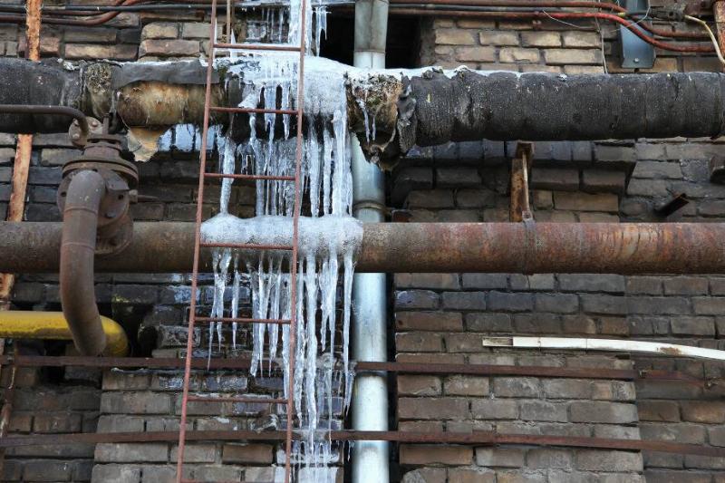 A frozen pipe on the outside of a building. 