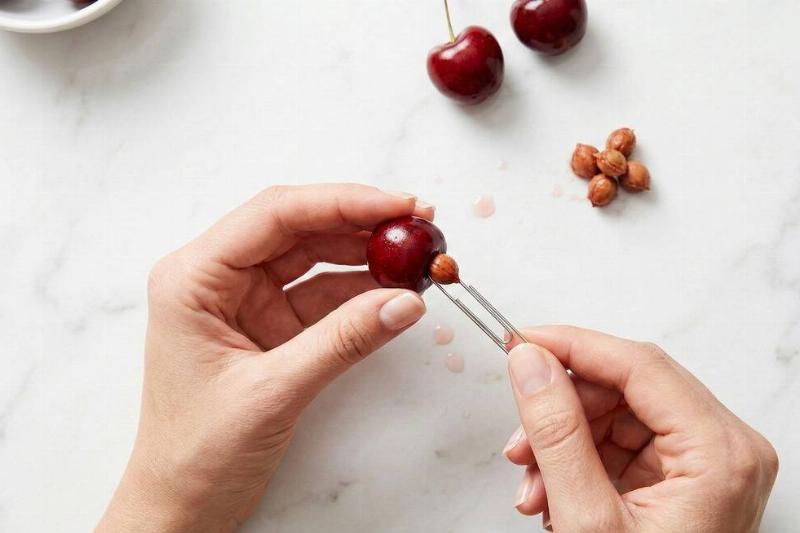 A paper clip being used to pit a cherry. 
