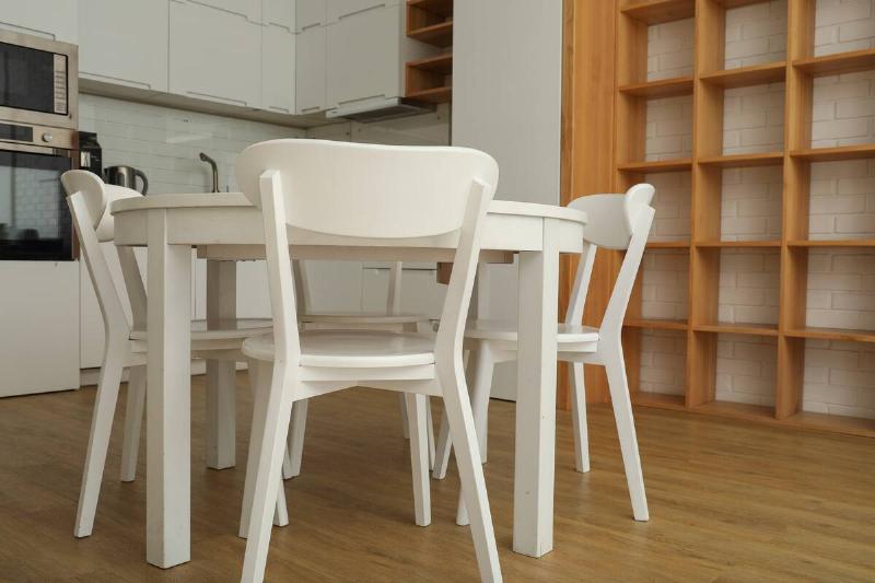 A round, white table with plastic chairs in the kitchen.