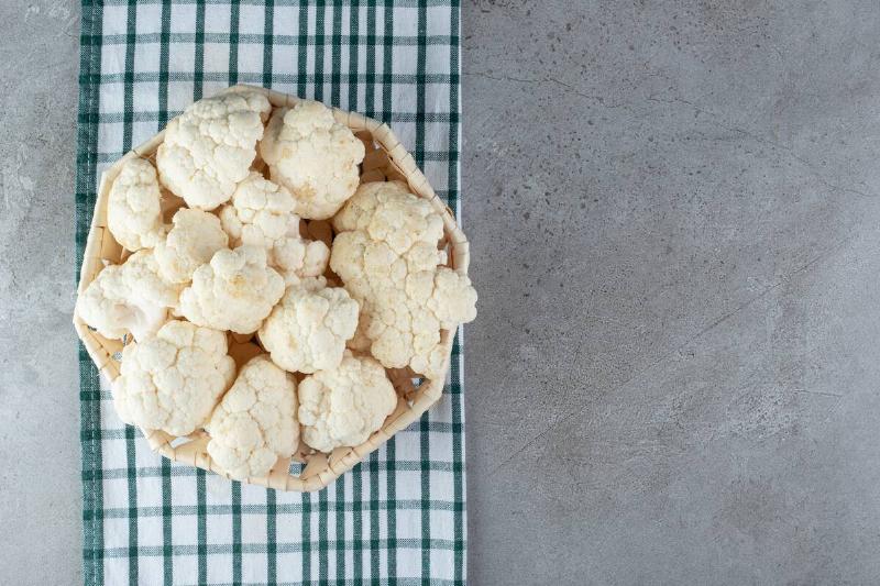 Bowl of cauliflower placed on a tea towel