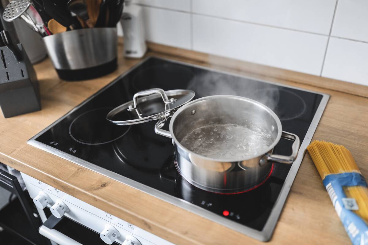 A pot of water boiling on top of a stove. 