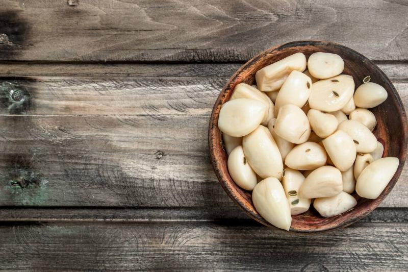 Bowl of garlic cloves on a picnic table