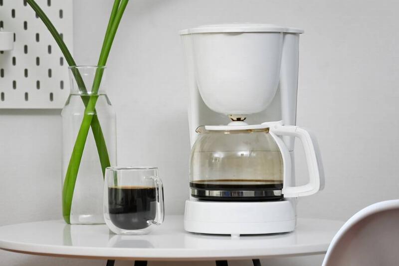 Coffee machine and coffee cup in office room.