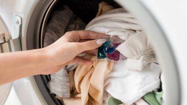 Laundry detergent pod on clothes in washer. 
