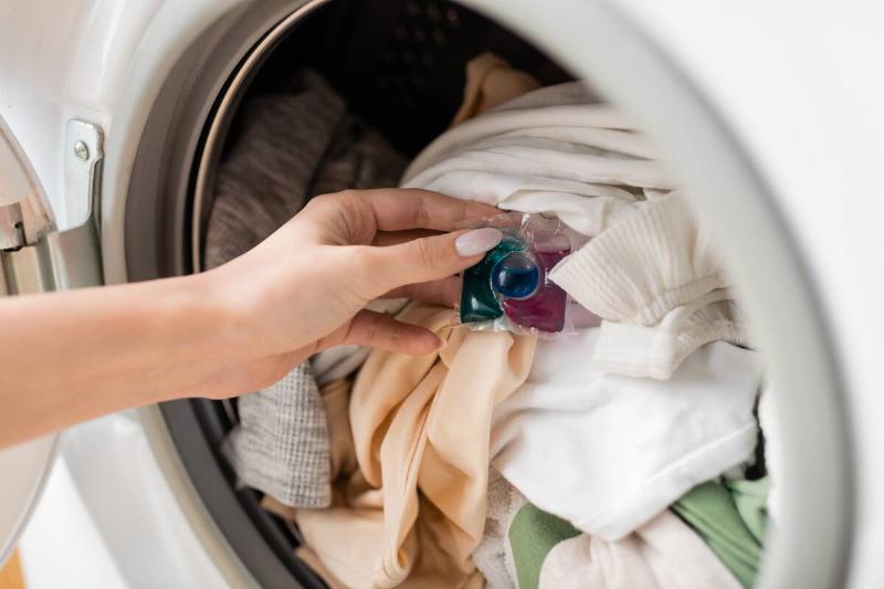 Laundry detergent pod on clothes in washer. 