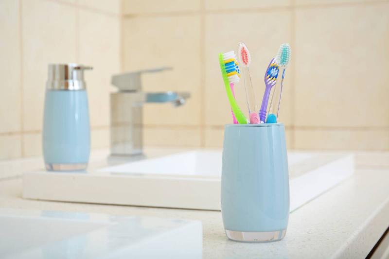 Toothbrush in cup near sink. 