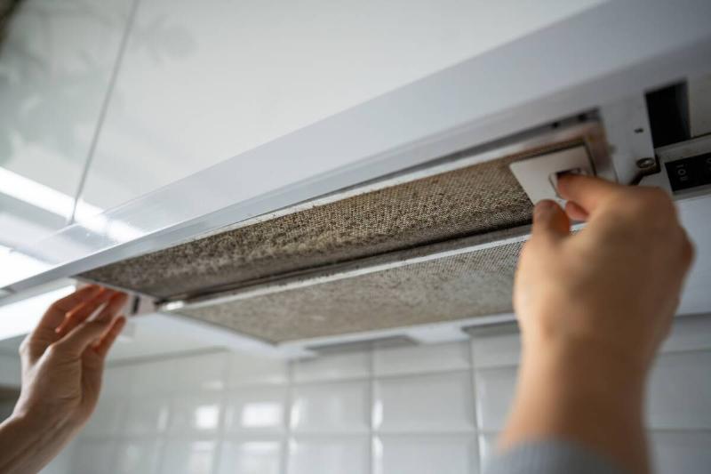 A kitchen vent hood that is greasy and dirty.