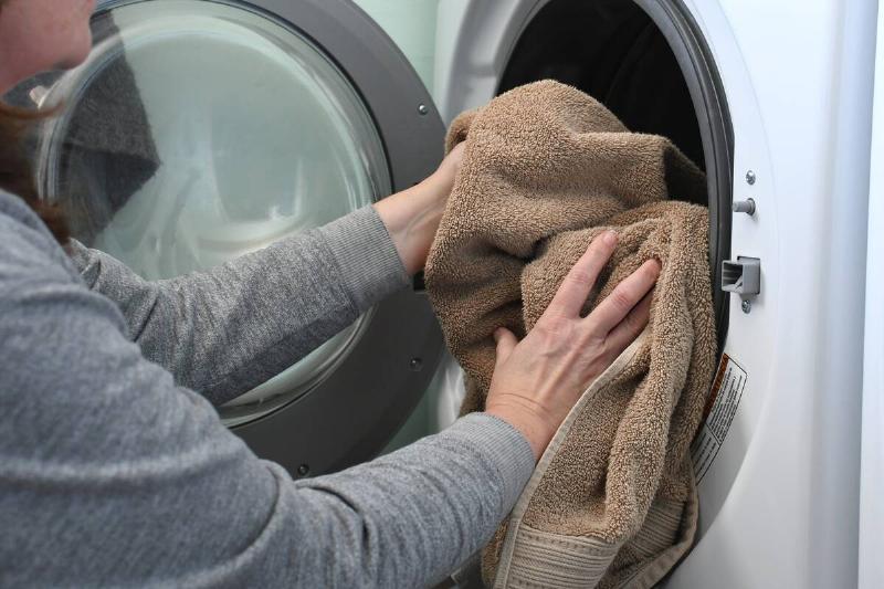 Putting a towel in the dryer. 