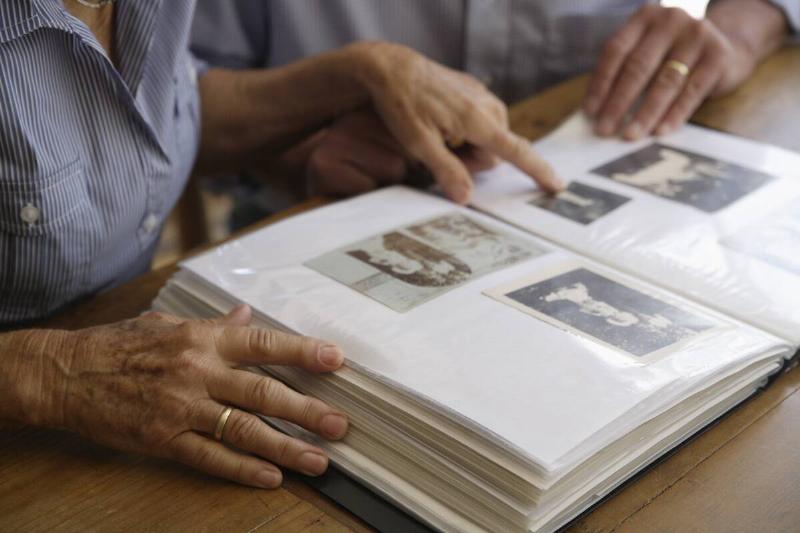 Two people looking through photo albums together. 