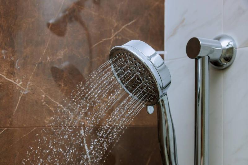 Water coming out of a bathroom shower head. 