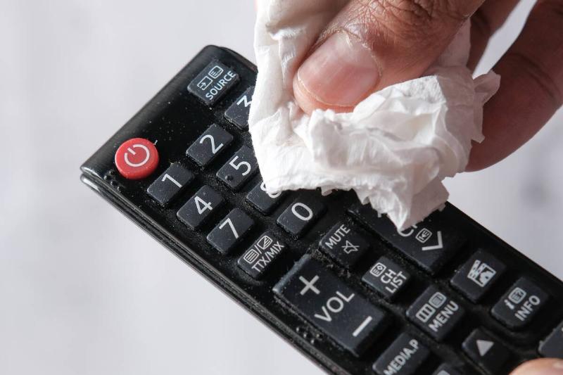 человек-рука-чистка-телевизор-пульт-контроллер-с-дезинфом-2026-01-07-02-25-45-utc Рука чистит пульт от телевизора дезинфицирующей влажной салфеткой.