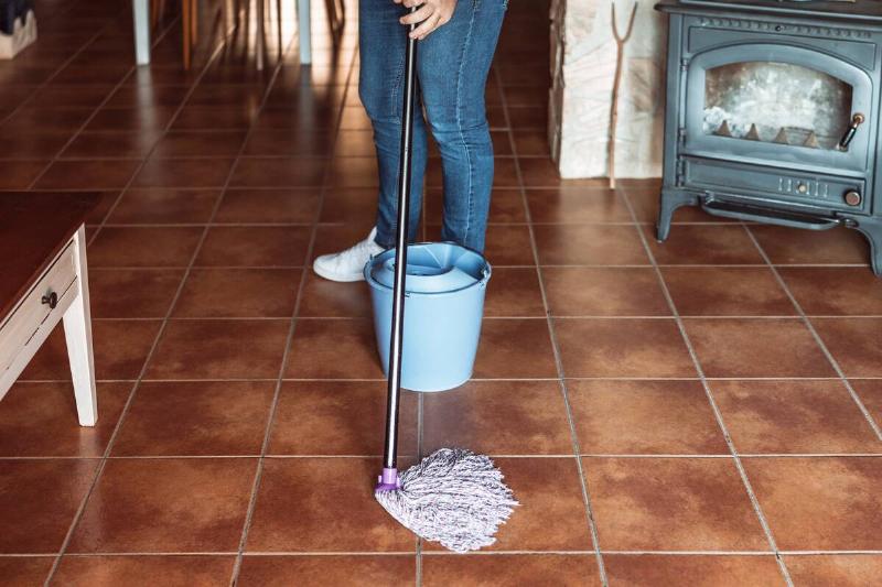 Man mopping a kitchen floor. 