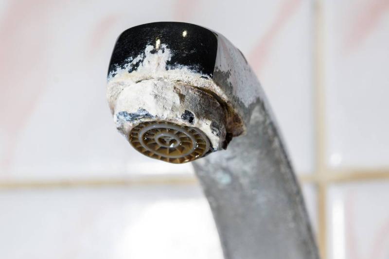 Mineral buildup on metal water faucet. 