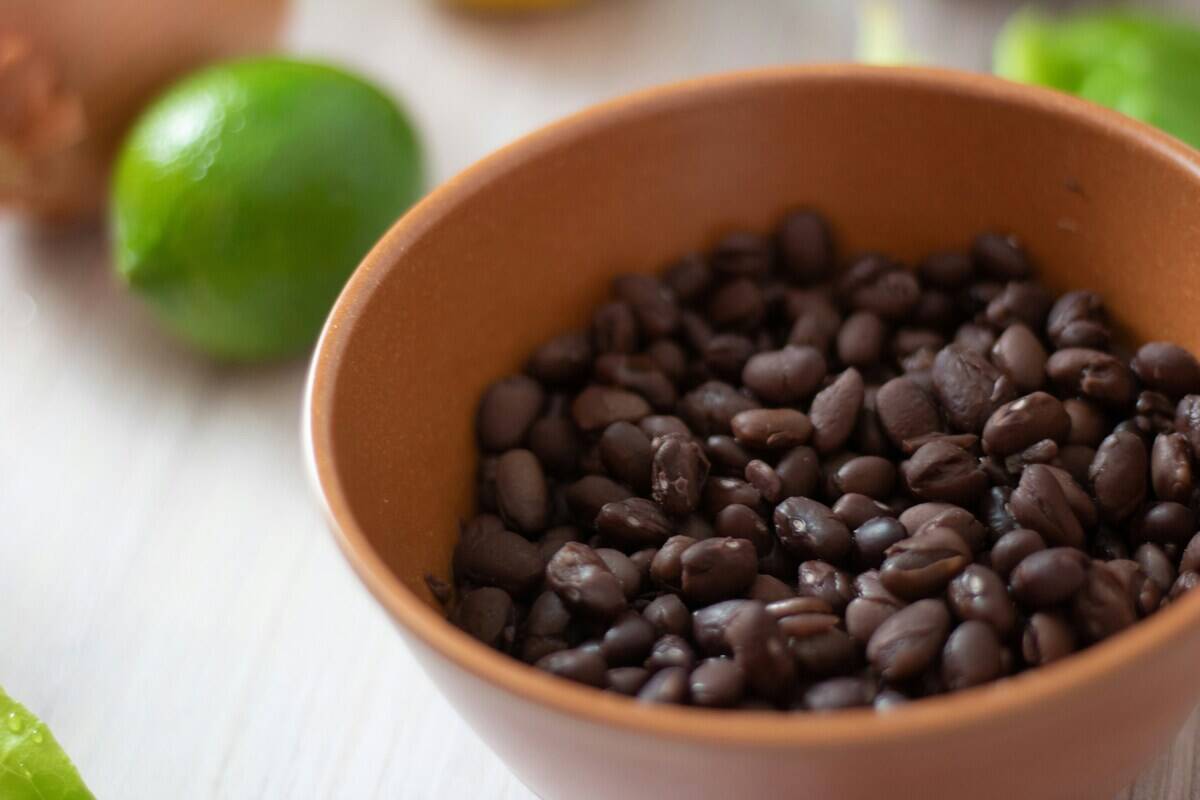 Bowl of black beans placed next to a lime