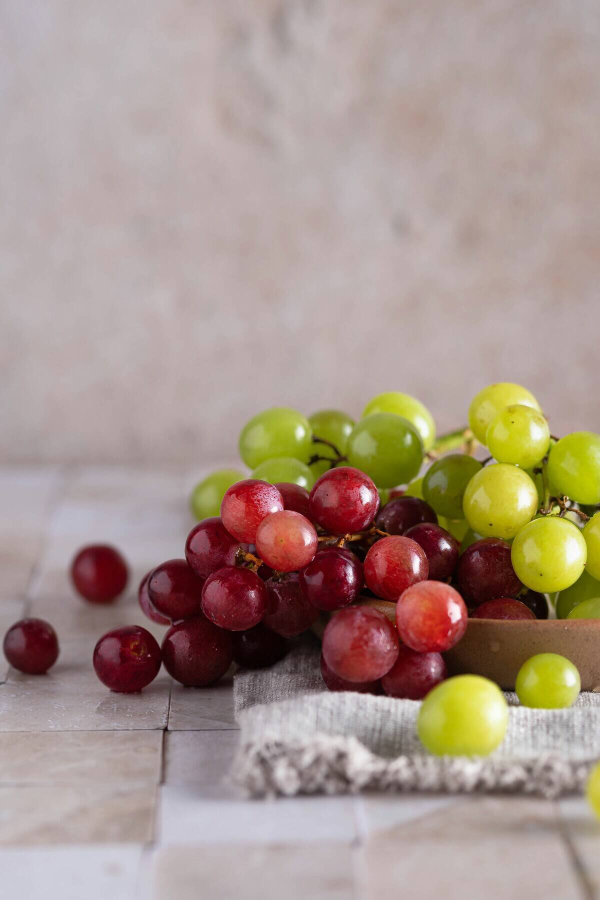 Red and green grapes spilling out of a bowl