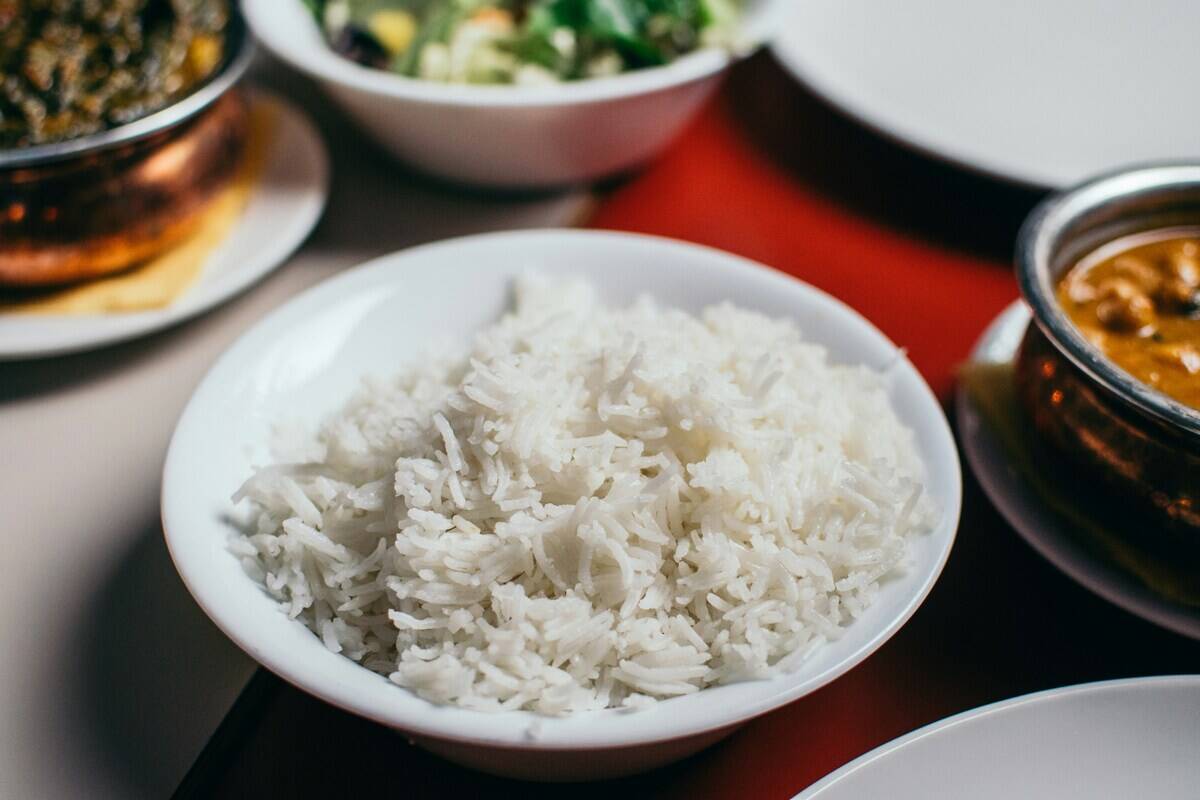 Bowl of cooked rice in the middle of a table featuring other dishes