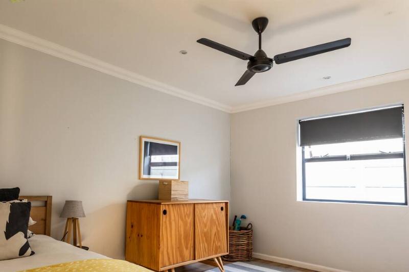 подушки-на-кровати-с-мебелью-в-спальне-дома-2026-01-09-10-58-16-utc Потолочный вентилятор в спальне.